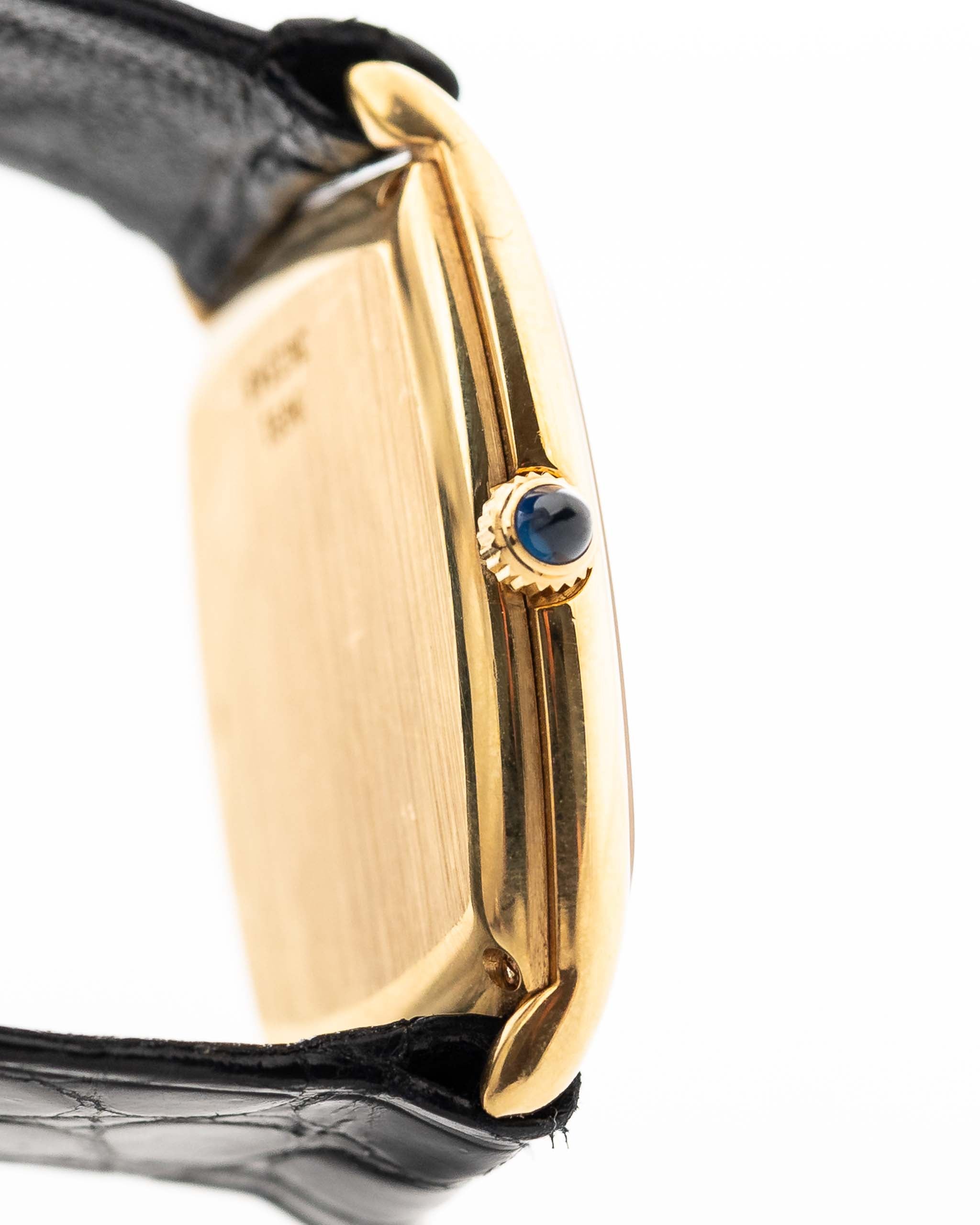 صورة جانبية مقرّبة لساعة بياجيه تونيه 9691 أونيكس عيار 18 قيراط من السبعينيات. 24 ملم مع علبة من الذهب الأصفر عيار 18 قيراط، وحركة تعبئة يدوية، وميناء أونيكس أسود وسوار جلدي أسود أصلي.