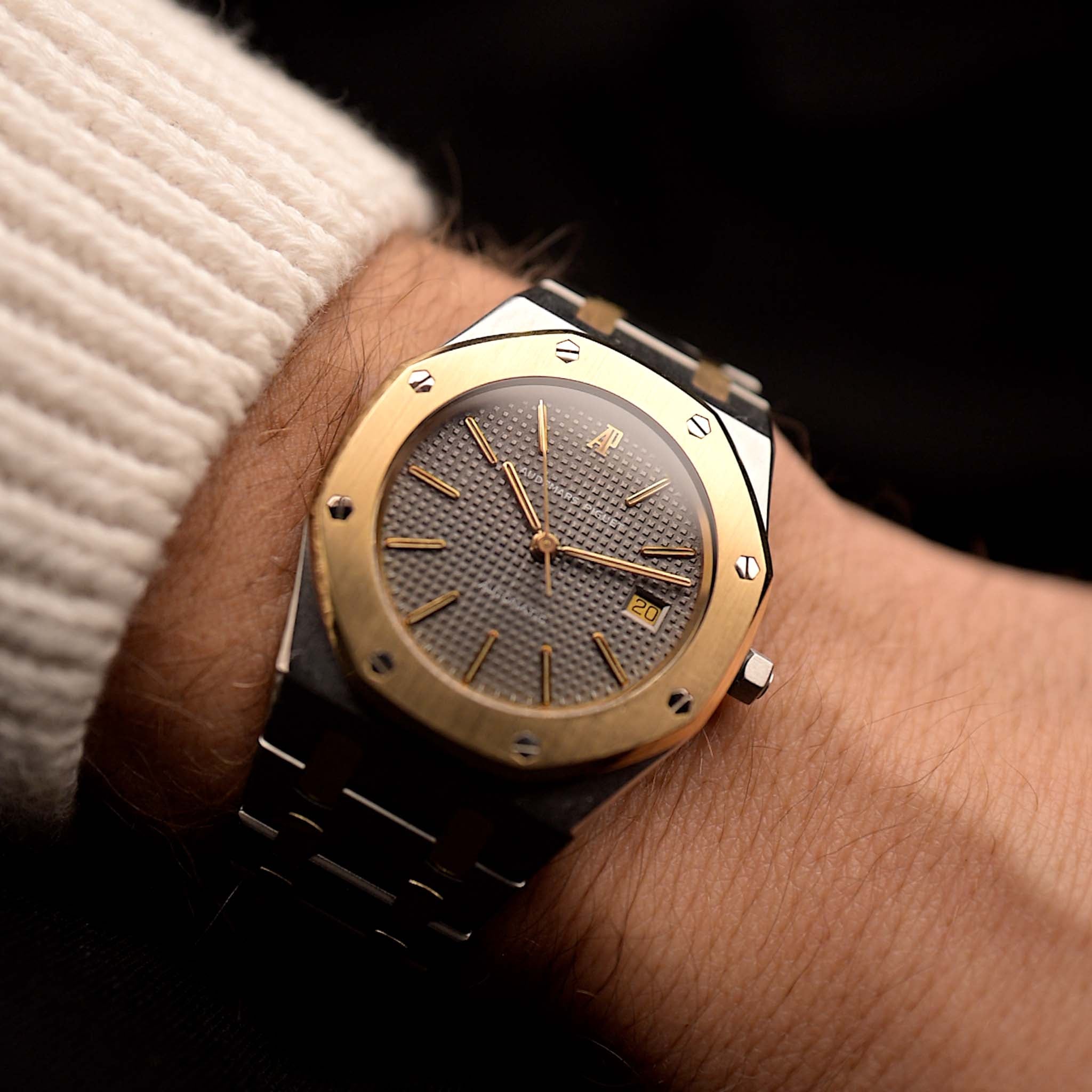 Audemars Piguet Royal Oak 14486SA Vintage Watch from the 1980s on a wrist on black background. 35mm wide in Two-Tone Stainless Steel & Yellow Gold, Automatic movement, Grey tapisserie dial and Two-Tone Bracelet.
