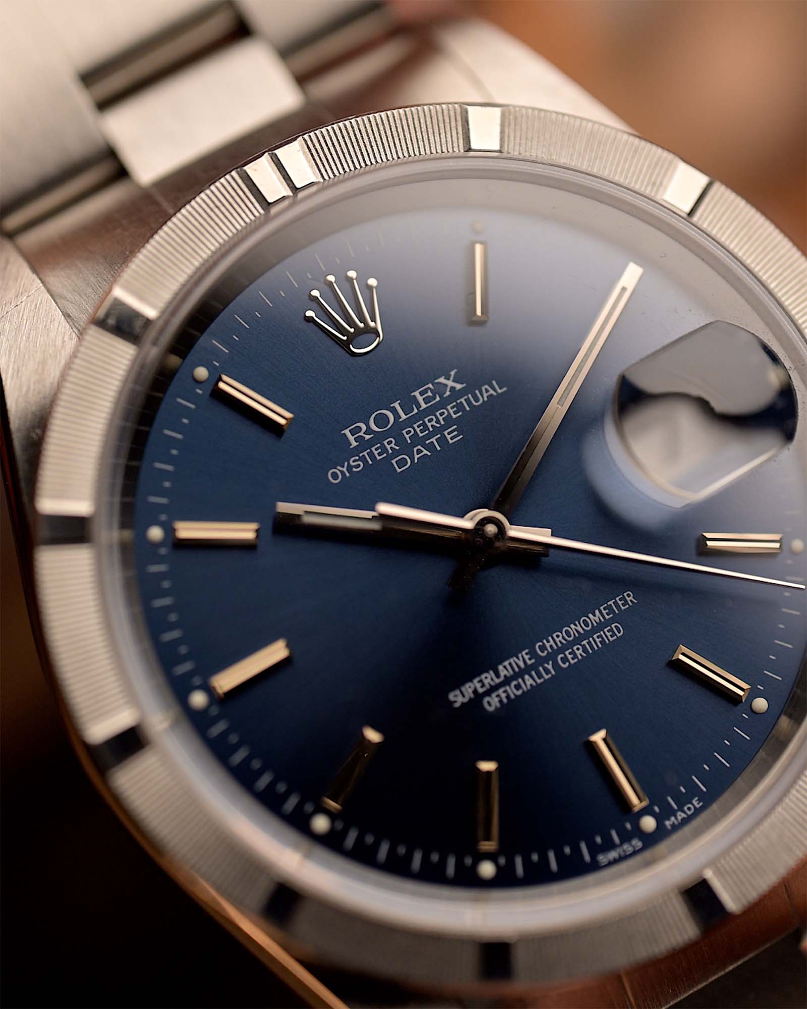 Rolex Oyster Perpetual 15210 Date watch with blue dial and stainless steel case on a blurred background