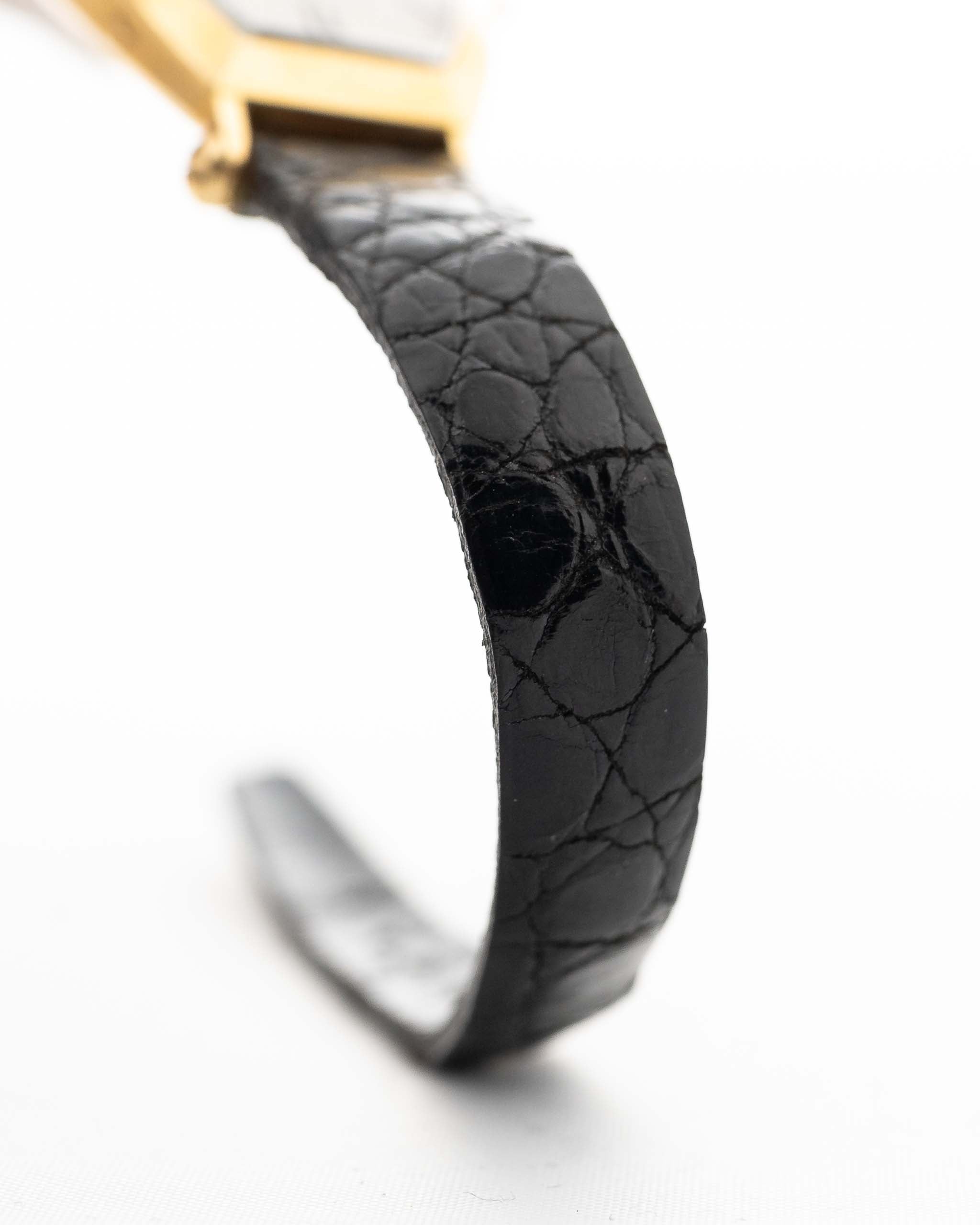 Nahaufnahme einer Vintage Cartier Tonneau 18k Guilloché Paris Lederarmband aus den 1980er Jahren. 39 mm mit Gehäuse aus 18 Karat Gelbgold, Uhrwerk mit Handaufzug, Original Guilloché Paris Zifferblatt und schwarzem Lederarmband.