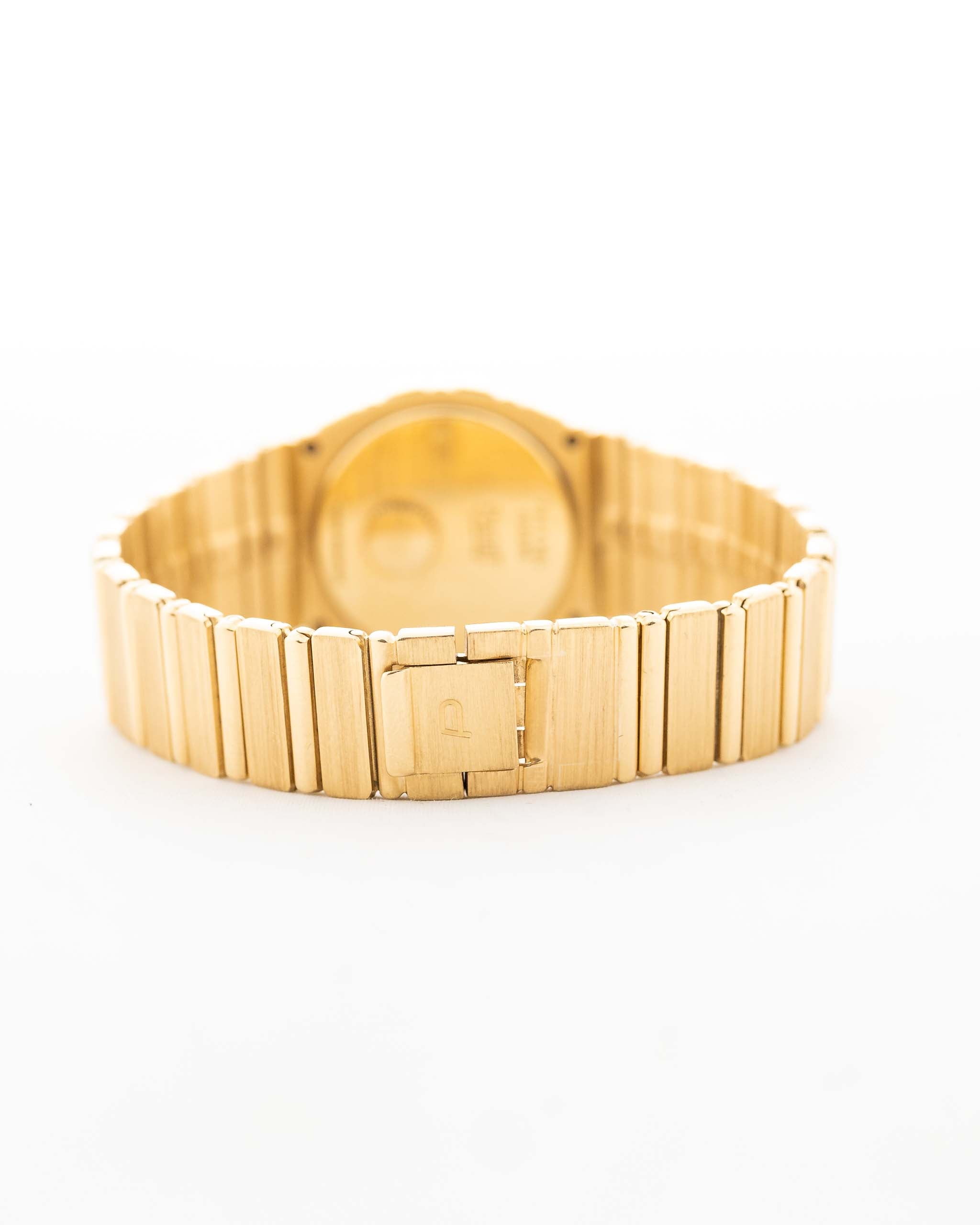 Nahaufnahme einer Vintage Piaget 791 Polo aus den 1980er Jahren. Mit 30mm Gehäuse, 18k Gelbgold, goldenem Zifferblatt, integriertem 18k Goldarmband und Quarzwerk.
