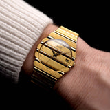 Foto einer Vintage Piaget Polo 15561 Date aus den 1980er Jahren an einem Handgelenk. In Gelbgold mit 31mm Gehäuse, Quarzwerk, originalem Goldzifferblatt und integriertem 18k Goldarmband.