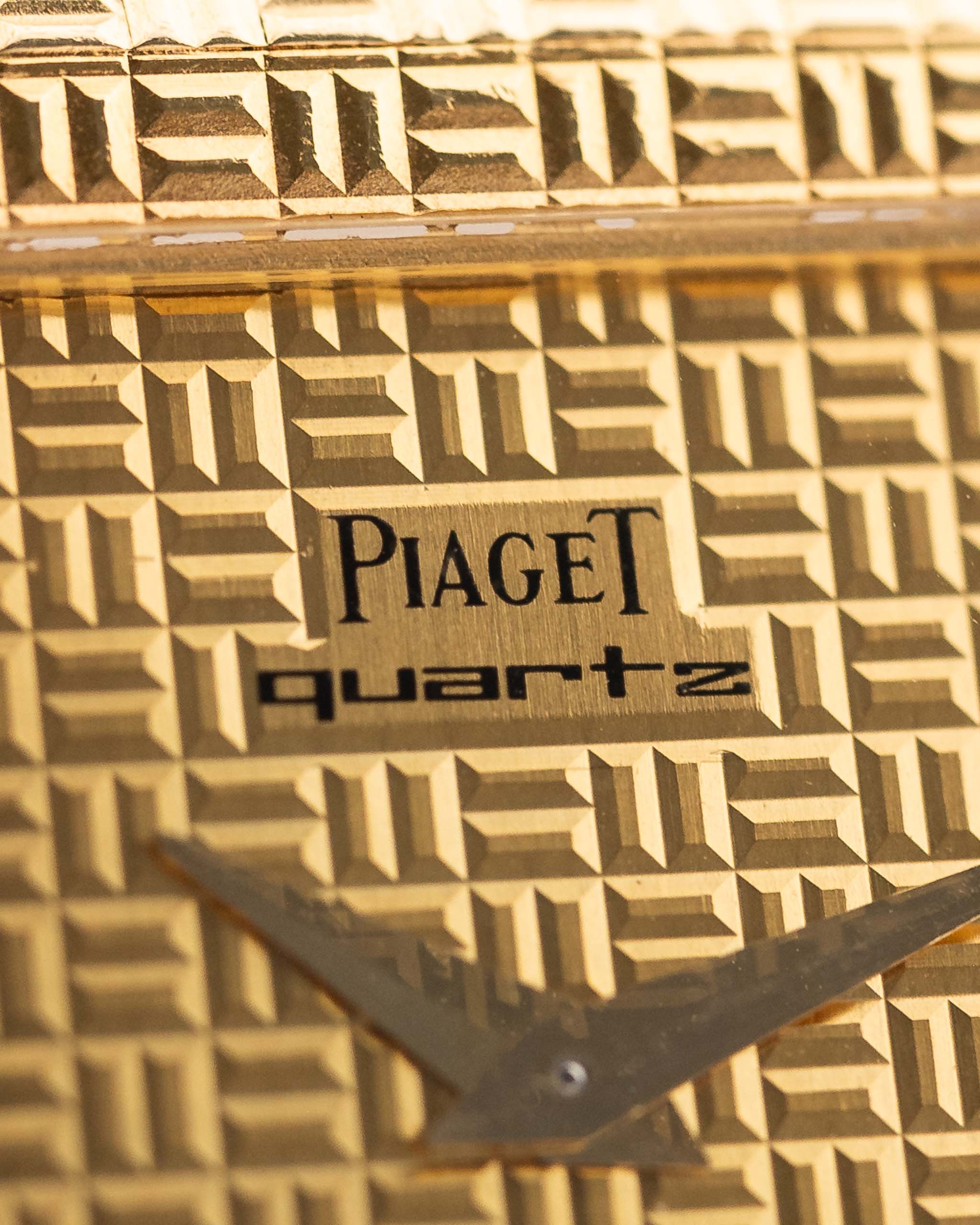 Nahaufnahme des Zifferblatts der Vintage Piaget Polo 7131 C5. 23 mm aus 18k Gelbgold mit guillochiertem Zifferblatt, integriertem 18k Goldarmband und Quarzwerk.