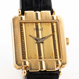 Nahaufnahme einer Vintage Piaget Polo 8193 Rectangular aus den 1980er Jahren an einem Handgelenk. In 18k Gelbgold, 20mm mit Quarzwerk, originalem goldenem Zifferblatt, originalem Lederarmband und 18k Goldschließe.
