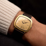 Vintage Piaget TV 12432 Automatikuhr 18k aus den 1970er Jahren an einem Handgelenk. 32,5 mm mit Gehäuse aus 18k Gelbgold, Automatikkaliber 12P1, goldenem Zifferblatt, Blattzeigern und Lederarmband.