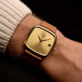 Vintage Piaget TV Watch 13773 Automatic Date 18k aus den 1970er Jahren an einem Handgelenk. 31,5 mm mit Gehäuse aus 18k Gelbgold, Automatikkaliber 12P1, makellosem goldenem Zifferblatt und Original-Lederarmband.