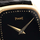 Nahaufnahme einer Piaget Tonneau 9691 Onyx 18k aus den 1970er Jahren. 24 mm mit Gehäuse aus 18k Gelbgold, Uhrwerk mit Handaufzug, schwarzem Onyx-Zifferblatt und schwarzem Original-Lederarmband.