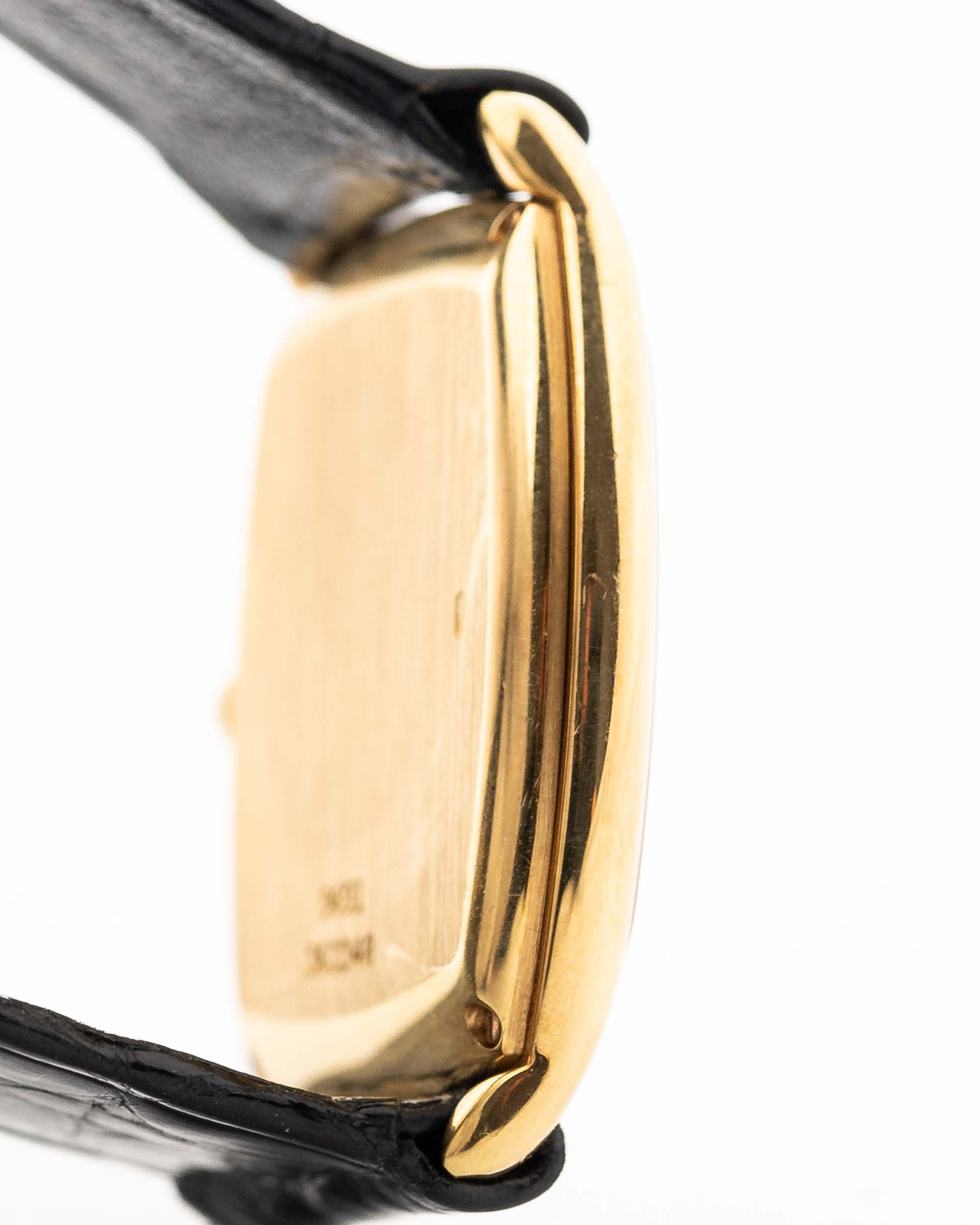 Nahaufnahme einer Piaget Tonneau 9691 Onyx 18k aus den 1970er Jahren. 24 mm mit Gehäuse aus 18k Gelbgold, Uhrwerk mit Handaufzug, schwarzem Onyx-Zifferblatt und schwarzem Original-Lederarmband.