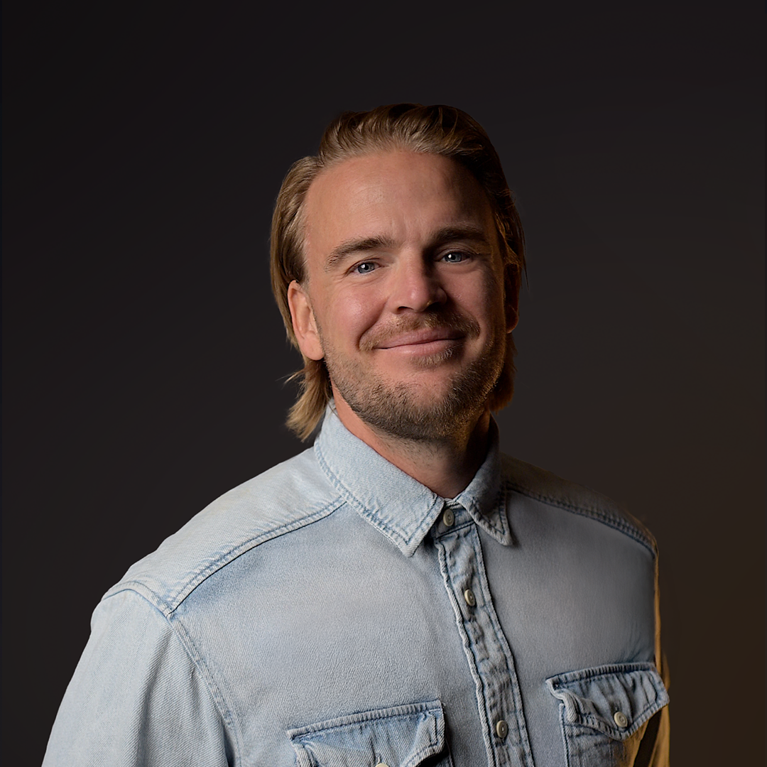 Hombre con chaqueta vaquera azul claro sobre fondo oscuro