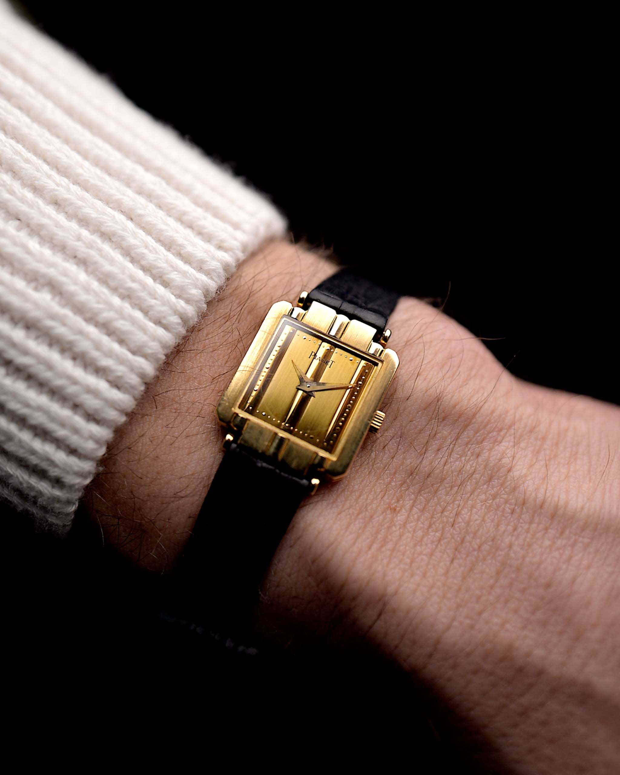 Photo d'une Piaget Polo 8193 Rectangulaire des années 1980 sur un poignet. En or jaune 18k, 20mm avec mouvement à quartz, cadran doré d'origine, bracelet en cuir d'origine et fermoir en or 18k.
