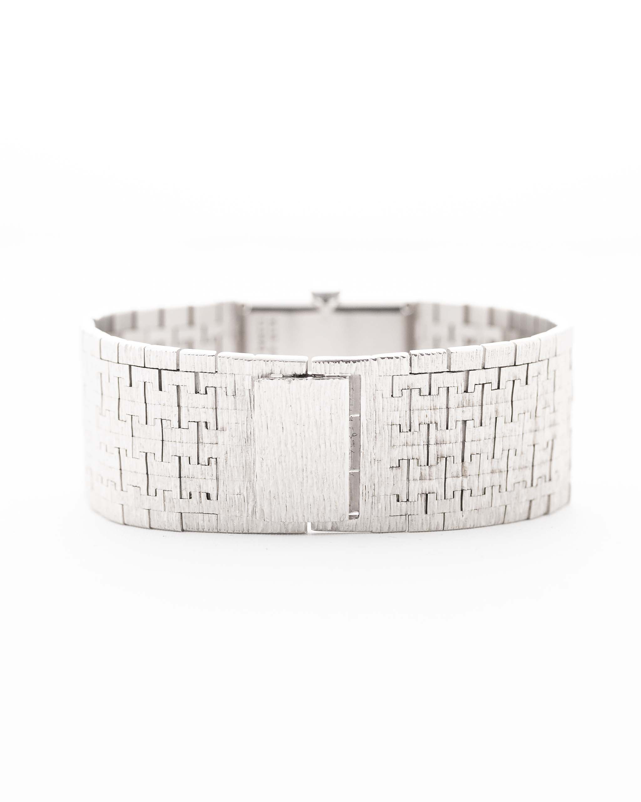 Photo en gros plan d'une Piaget Protocole 9133 Bark 18k des années 1970. 23mm en or blanc 18k avec mouvement à remontage manuel, cadran original en écorce et bracelet intégré.