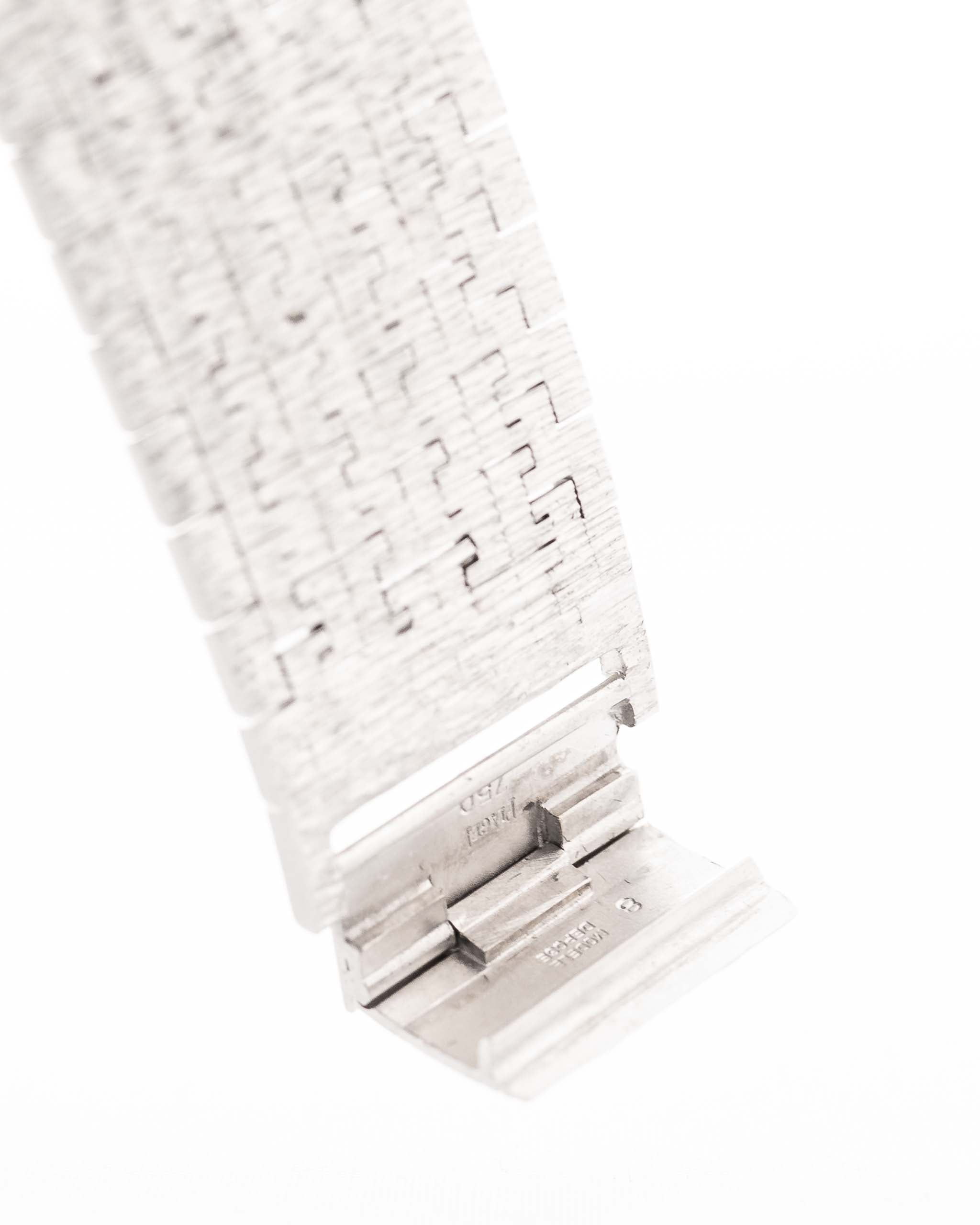 Photo en gros plan d'une Piaget Protocole 9133 Bark 18k des années 1970. 23mm en or blanc 18k avec mouvement à remontage manuel, cadran original en écorce et bracelet intégré.