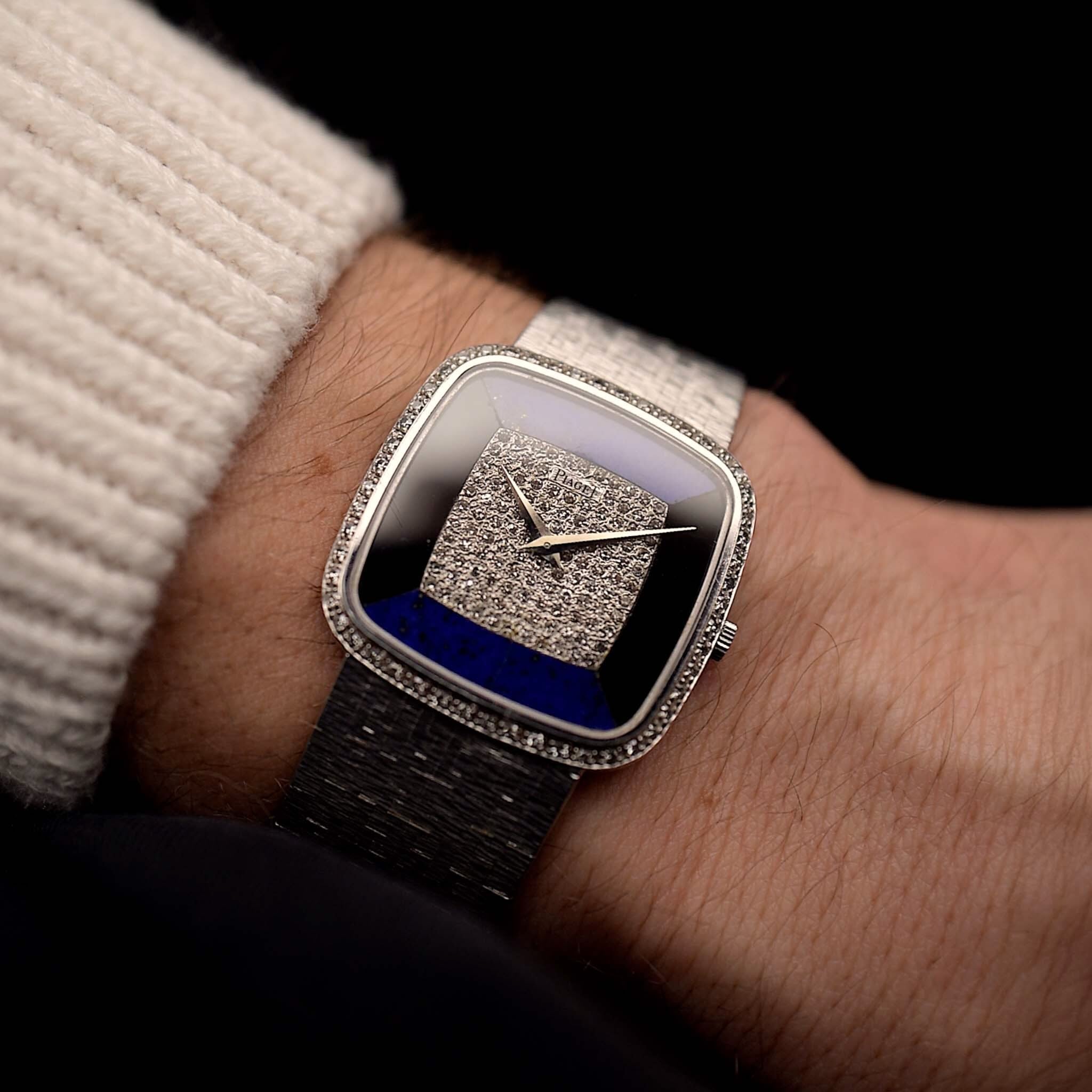Montre vintage Piaget Square 9775 avec Lapis Onyx Diamant des années 70 sur un poignet. 30mm en or blanc 18k avec mouvement à remontage manuel, cadran en Onyx & Lapis Lazuli, 120 Diamants et bracelet intégré.