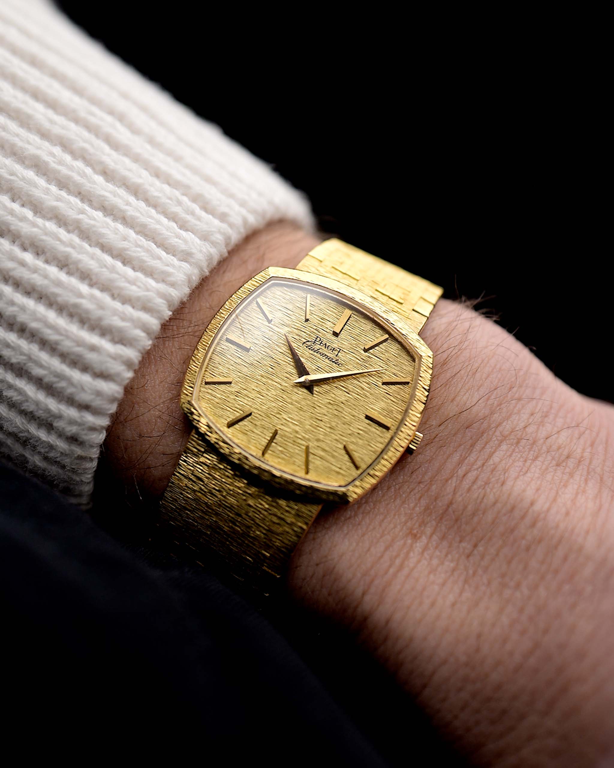 Photo d'une Piaget TV 12401 Automatic 18k des années 1970 sur un poignet. Boîtier de 32,5 mm en or jaune 18k avec mouvement automatique, cadran martelé sans défaut d'origine et bracelet intégré en 18k.