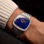 Montre Piaget TV 12735 Lapis Lazuli Diamond des années 1970 sur un poignet. 32mm en or blanc 18k avec calibre automatique 12P1, cadran en lazuli, lunette en diamant et bracelet intégré en or blanc 18k. 12P1, cadran en Lapis Lazuli, lunette en diamant et bracelet intégré en or blanc 18k.