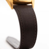 Photo en gros plan d'une Rolex Datejust 1601 Tiger Eye de 1974. 36mm avec boîtier en or jaune 18K, cadran en pierre Tiger Eye, mouvement automatique et bracelet en cuir.