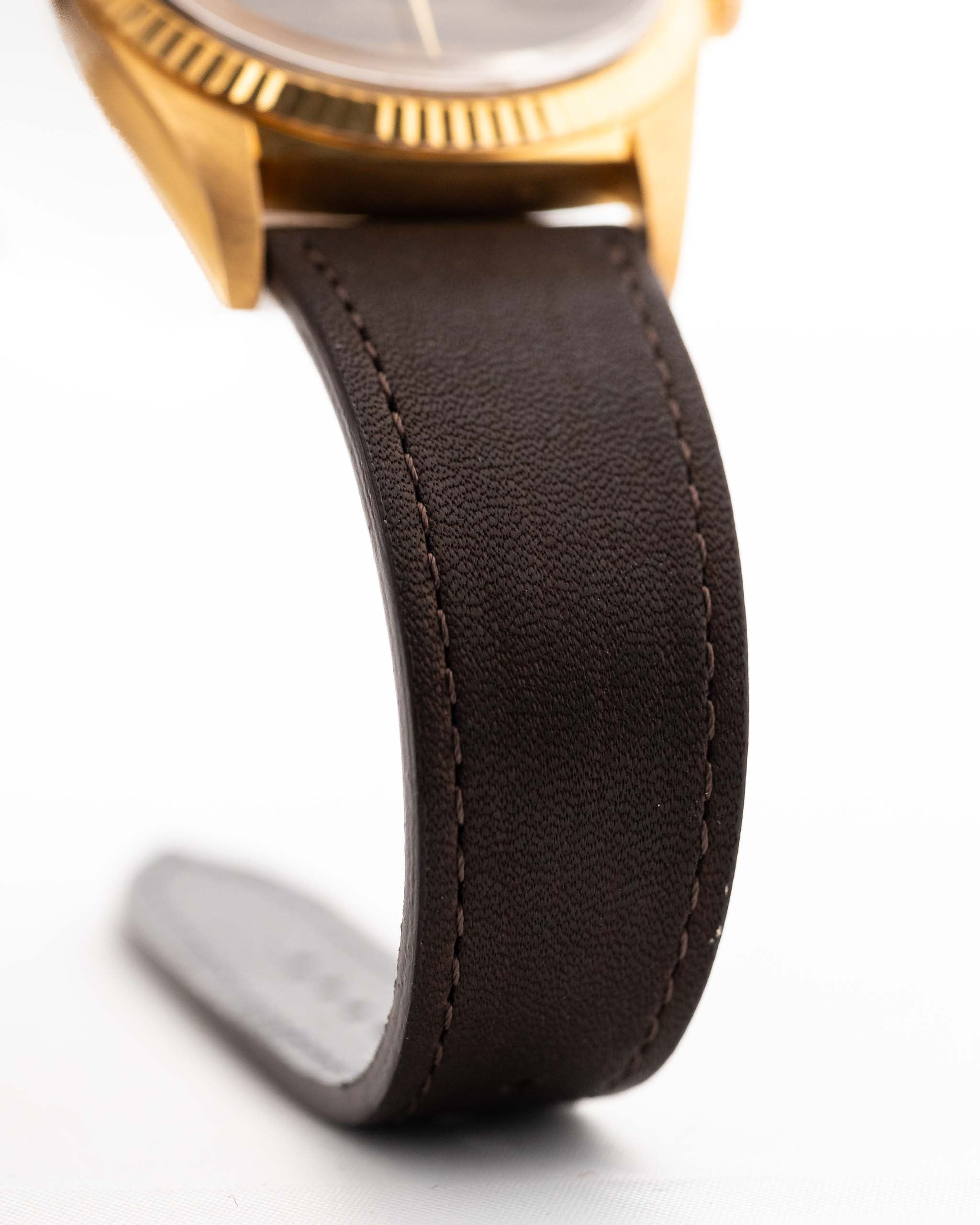 Photo en gros plan d'une Rolex Datejust 1601 Tiger Eye de 1974. 36mm avec boîtier en or jaune 18K, cadran en pierre Tiger Eye, mouvement automatique et bracelet en cuir.