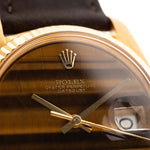 Photo en gros plan d'une Rolex Datejust 1601 Tiger Eye de 1974. 36mm avec boîtier en or jaune 18K, cadran en pierre Tiger Eye, mouvement automatique et bracelet en cuir.