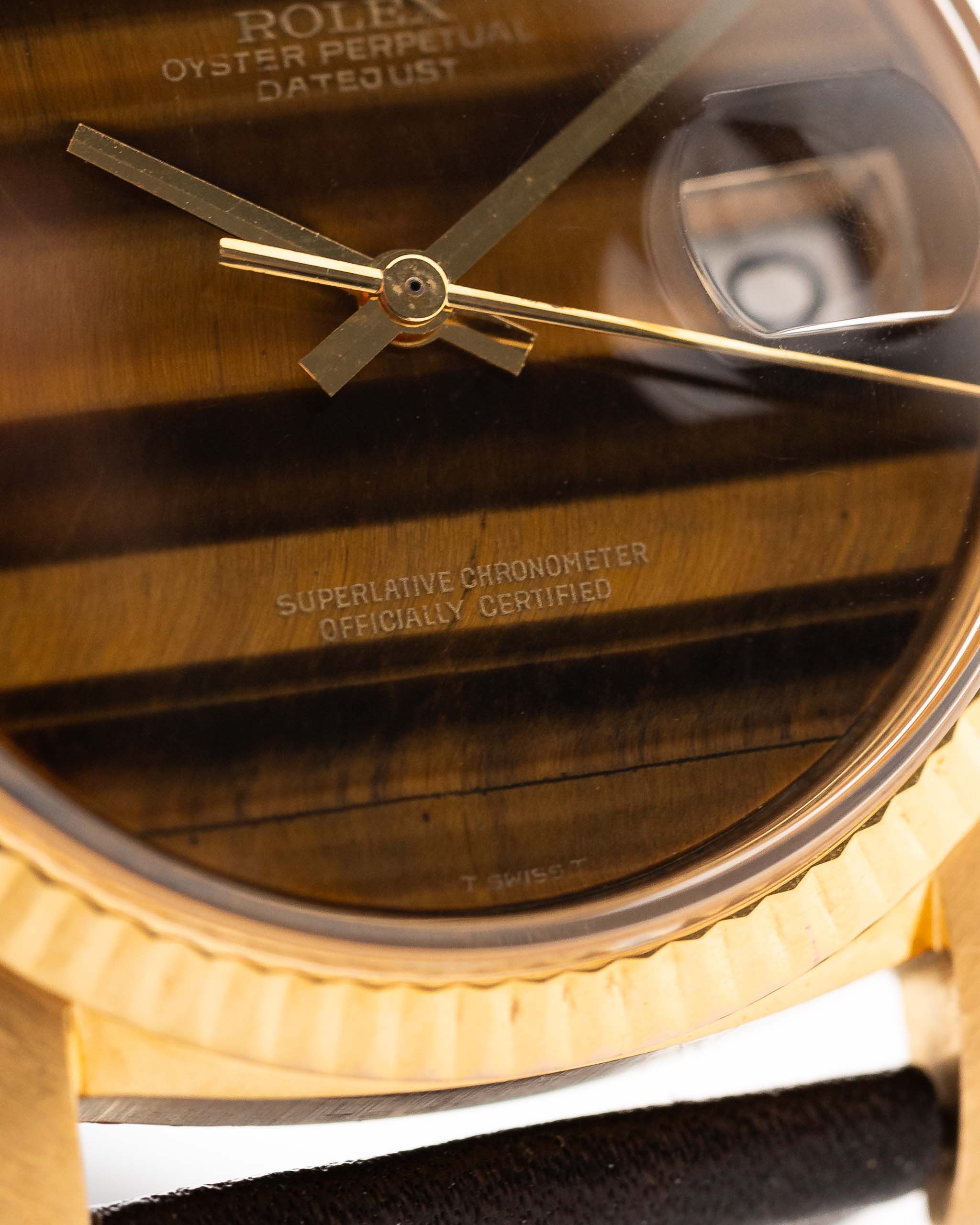 Photo en gros plan d'une Rolex Datejust 1601 Tiger Eye de 1974. 36mm avec boîtier en or jaune 18K, cadran en pierre Tiger Eye, mouvement automatique et bracelet en cuir.