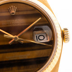 Photo en gros plan d'une Rolex Datejust 1601 Tiger Eye de 1974. 36mm avec boîtier en or jaune 18K, cadran en pierre Tiger Eye, mouvement automatique et bracelet en cuir.