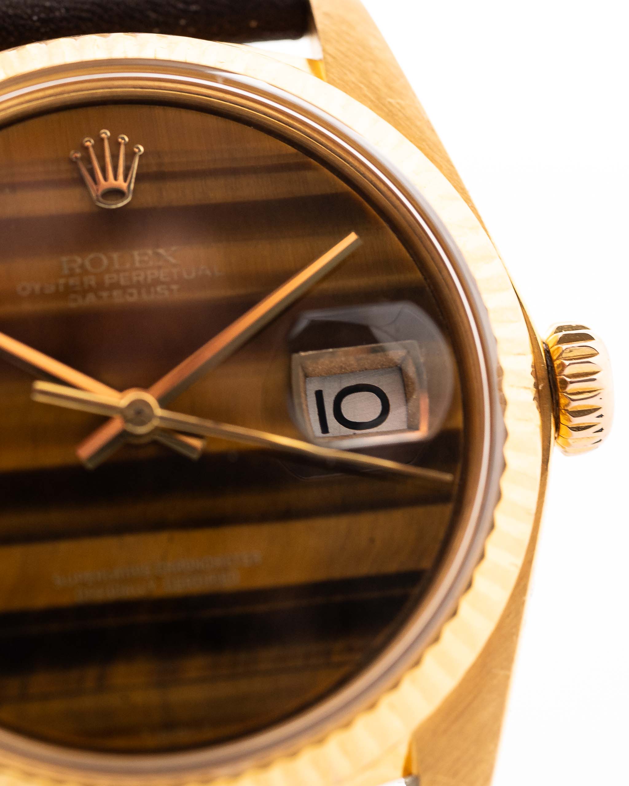 Photo en gros plan d'une Rolex Datejust 1601 Tiger Eye de 1974. 36mm avec boîtier en or jaune 18K, cadran en pierre Tiger Eye, mouvement automatique et bracelet en cuir.