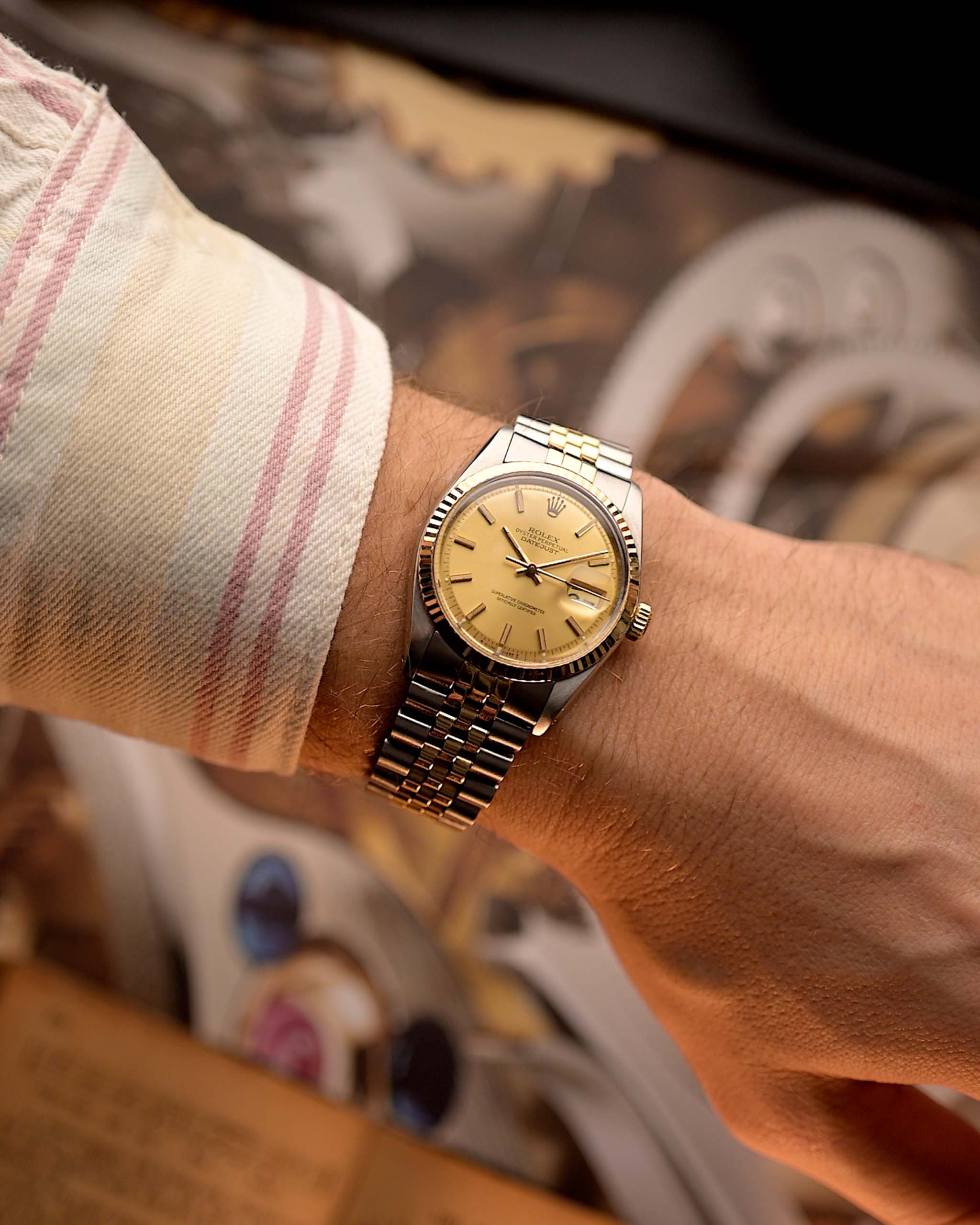 Rolex Datejust 1601 Two Tone gold-steel de 1970 au poignet sur un fond flou.