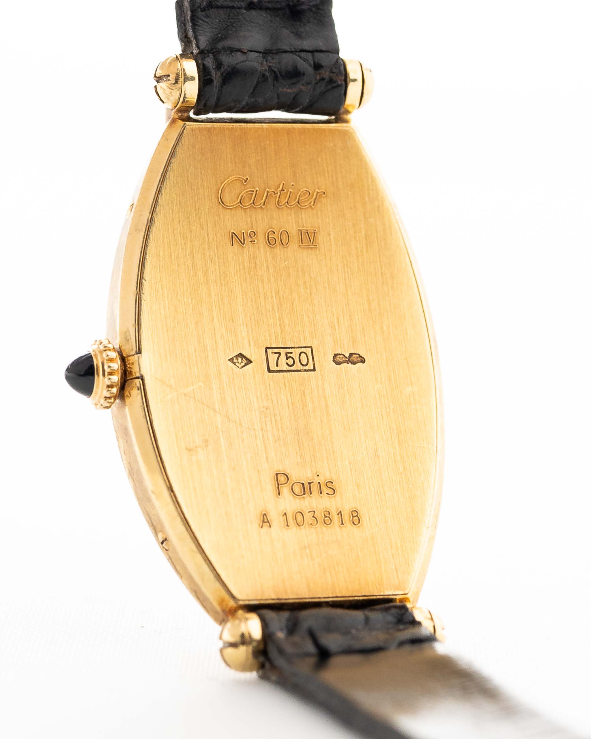 Foto ravvicinata di un Cartier Tonneau 18k Guilloché Paris vintage degli anni Ottanta. 39 mm con cassa in oro giallo 18k, movimento a carica manuale, quadrante originale Guilloché Paris e cinturino in pelle nera.