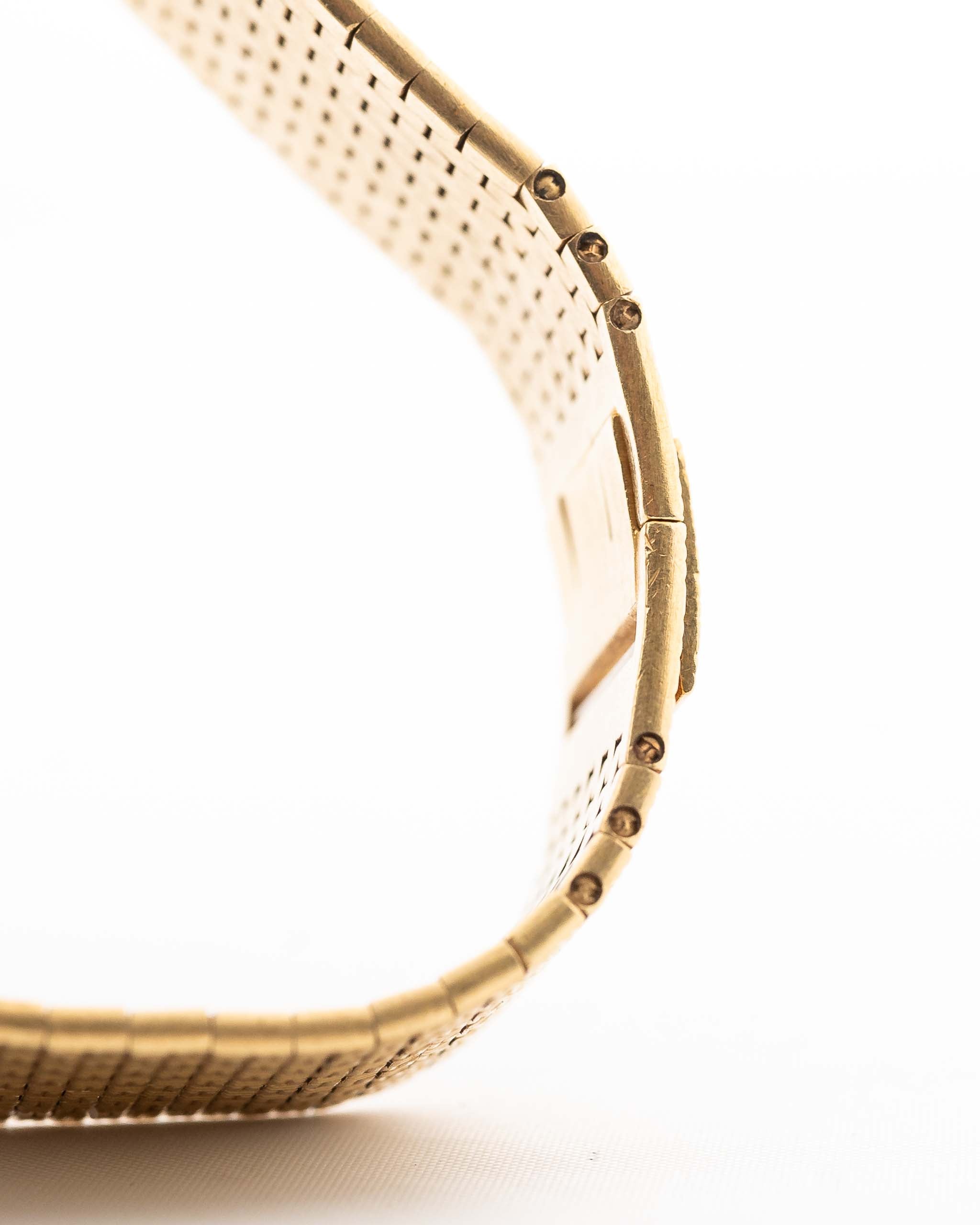 Primo piano del bracciale vintage Piaget Polo 7131 C5. 23 mm in oro giallo 18 carati con quadrante guilloché, bracciale integrato in oro 18 carati e movimento al quarzo.