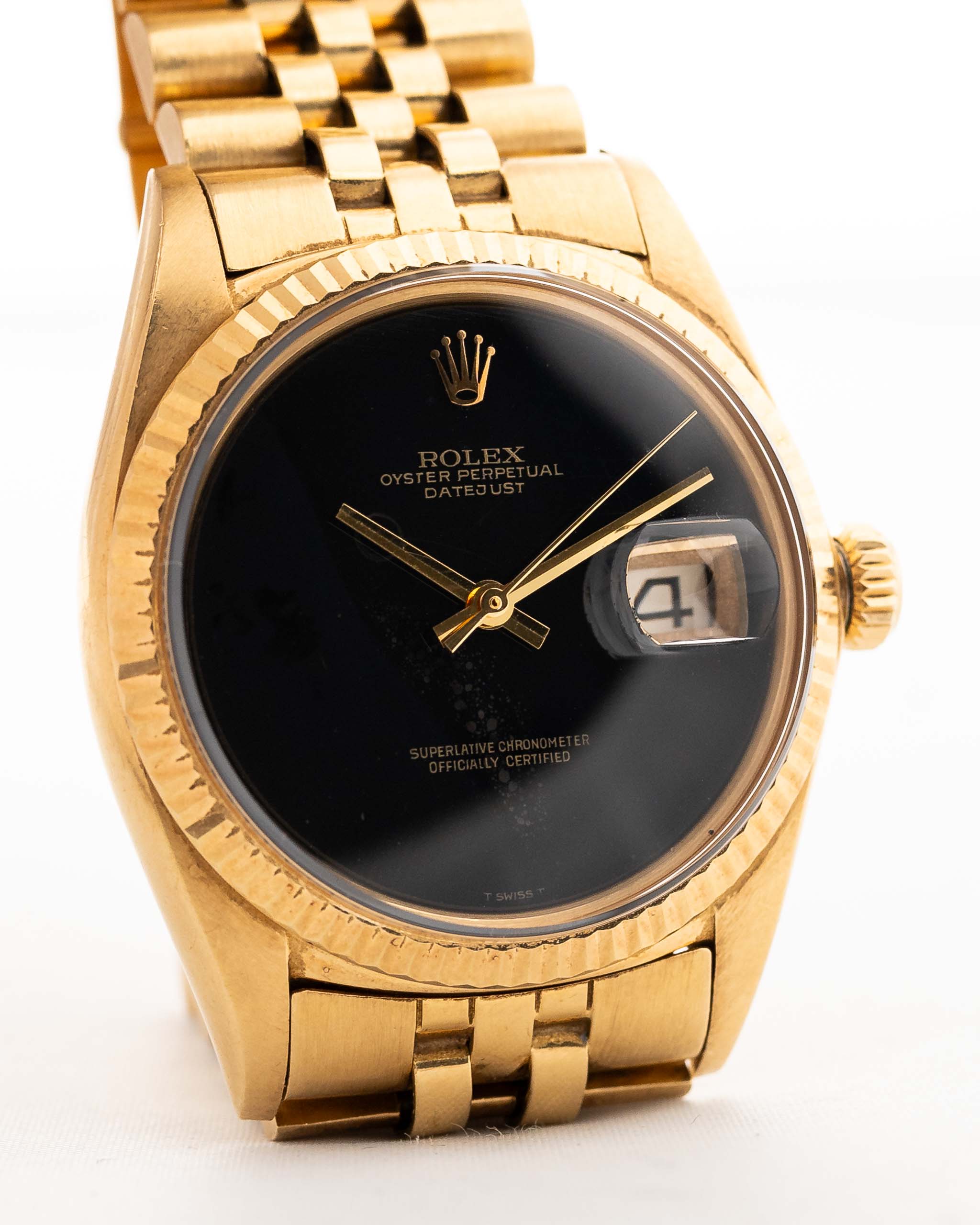 Una foto ravvicinata di un Rolex Datejust 36 mm 1601 Onyx in oro giallo del 1969 su un polso. in oro giallo 18 carati con calibro automatico 157, quadrante originale in onice e bracciale Jubilee.