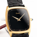 1970 年代 Piaget Tonneau 9691 Onyx 18K 手錶特寫照片。24mm 18K 黃金錶殼、手動上鏈機芯、黑色縞瑪瑙錶盤和原裝黑色真皮錶帶。
