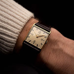 ساعة Vacheron Constantin Square 18k Dress عتيقة من الذهب الأصفر، ميناء فضي، يدوية، حزام جلدي بني على معصم على خلفية سوداء، فيديو