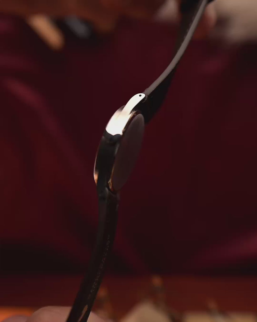 ساعة أوميغا أرت ديكو عتيقة على طراز أوميغا آرت ديكو تتميز بميناء من السلمون وعلبة من الفولاذ المقاوم للصدأ وحركة تعبئة يدوية وحزام جلدي بني اللون على المعصم على خلفية ضبابية، فيديو