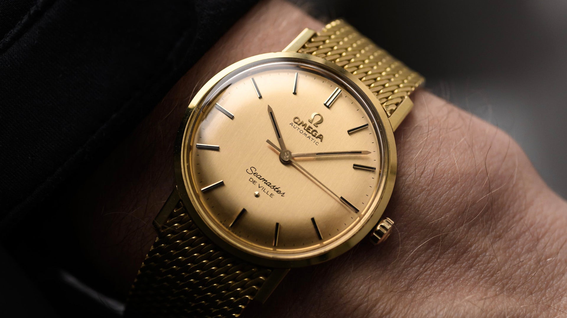 wristshot of a golden 1970s vintage Omega Seamaster De Ville