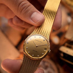 Vintage Audemars Piguet Automatic watch from the 1980s, 31.5mm 18k yellow gold case, gold dial, 11 diamond hour markers on blurred background