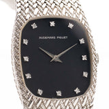 A closeup photo of a vintage Audemars Piguet Cobra watch from 1980s on a wrist. White gold, 27mm, Manual wind Cal. 2080, Original flawless dial with 12 diamonds and White gold mesh bracelet.