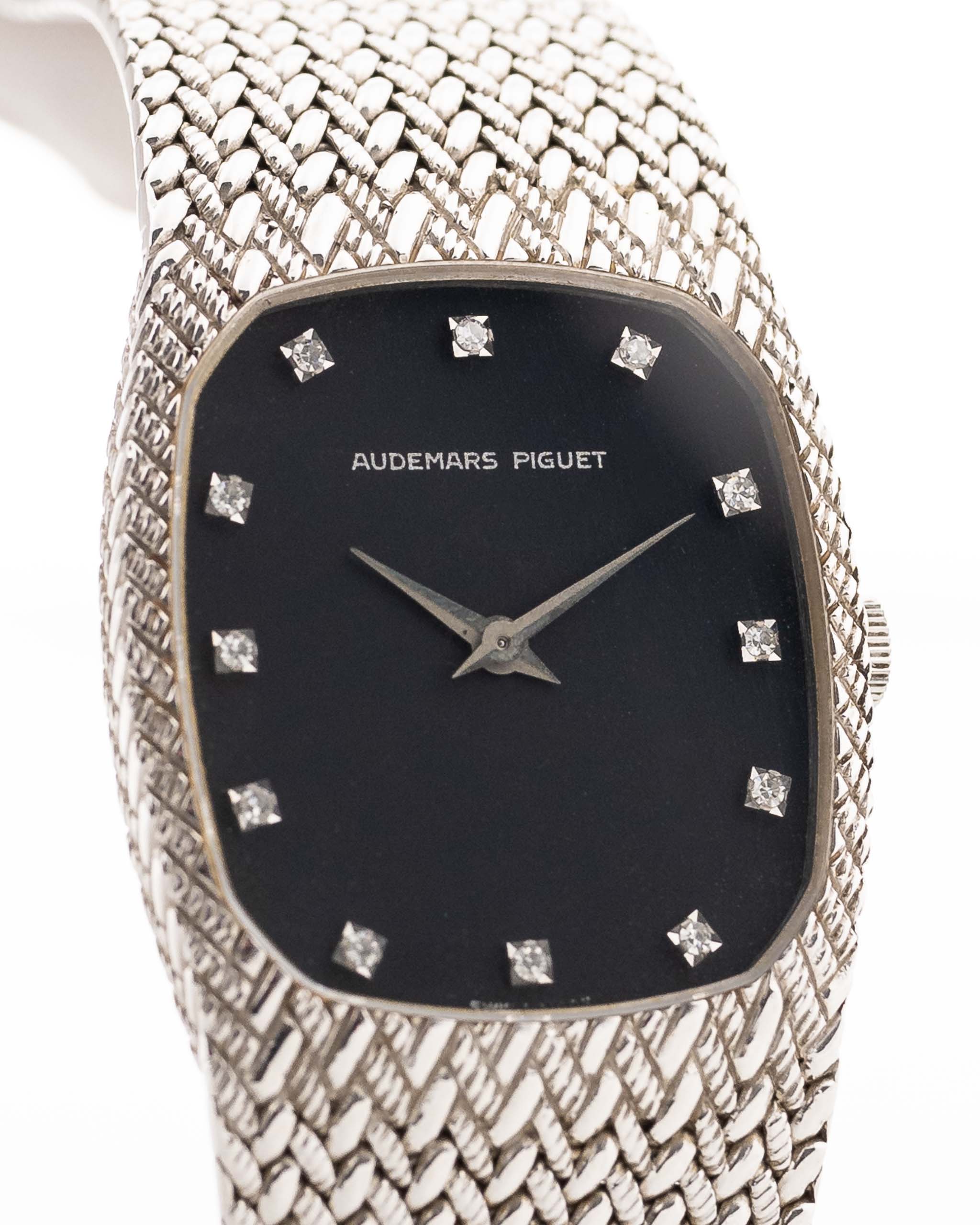 A closeup photo of a vintage Audemars Piguet Cobra watch from 1980s on a wrist. White gold, 27mm, Manual wind Cal. 2080, Original flawless dial with 12 diamonds and White gold mesh bracelet.
