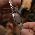 Close-up of a Vintage Audemars Piguet Cobra watch case back, 18k white gold, white gold bracelet, held in hands with a blurred background