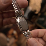 Close-up of a Vintage Audemars Piguet Cobra watch case back, 18k white gold, white gold bracelet, held in hands with a blurred background