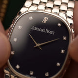 Close-up of a Vintage Audemars Piguet Cobra watch, 18k white gold, night blue diamond dial, manual movement, integrated bracelet, blurred background