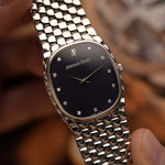 Vintage Audemars Piguet Cobra watch, 18k white gold, night blue diamond dial, manual movement, white gold bracelet, held by a hand against a blurred background