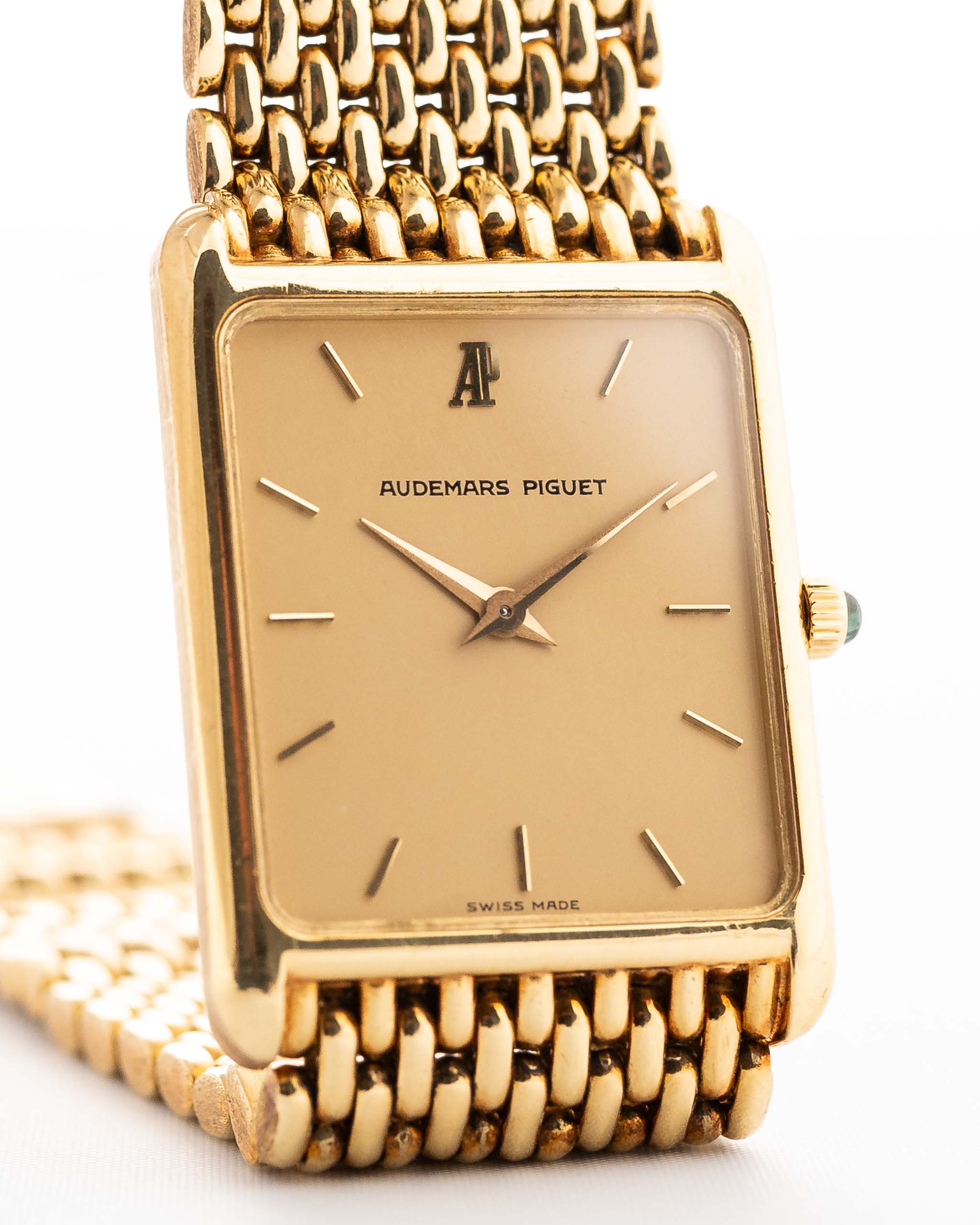 Closeup Photo of a Audemars Piguet 18k Tank from the 1980s. 25mm case in 18k Yellow Gold with Manual wind movement, Original golden dial, Hands with sapphire cabochon and Beads of rice bracelet.
