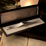 Watch in a box on top of an open book with a warm glow