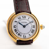 Vintage Cartier Ellipse watch in 18k gold, white dial Paris signature, original red leather strap, on wrist, white background