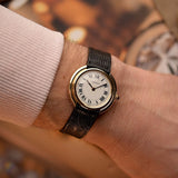 1970年代卡地亞 Vendôme 復古腕錶，18K 黃金錶殼，白色 MK2 錶盤，自動上鏈機芯，錶帶佩戴於手腕上，背景為模糊效果