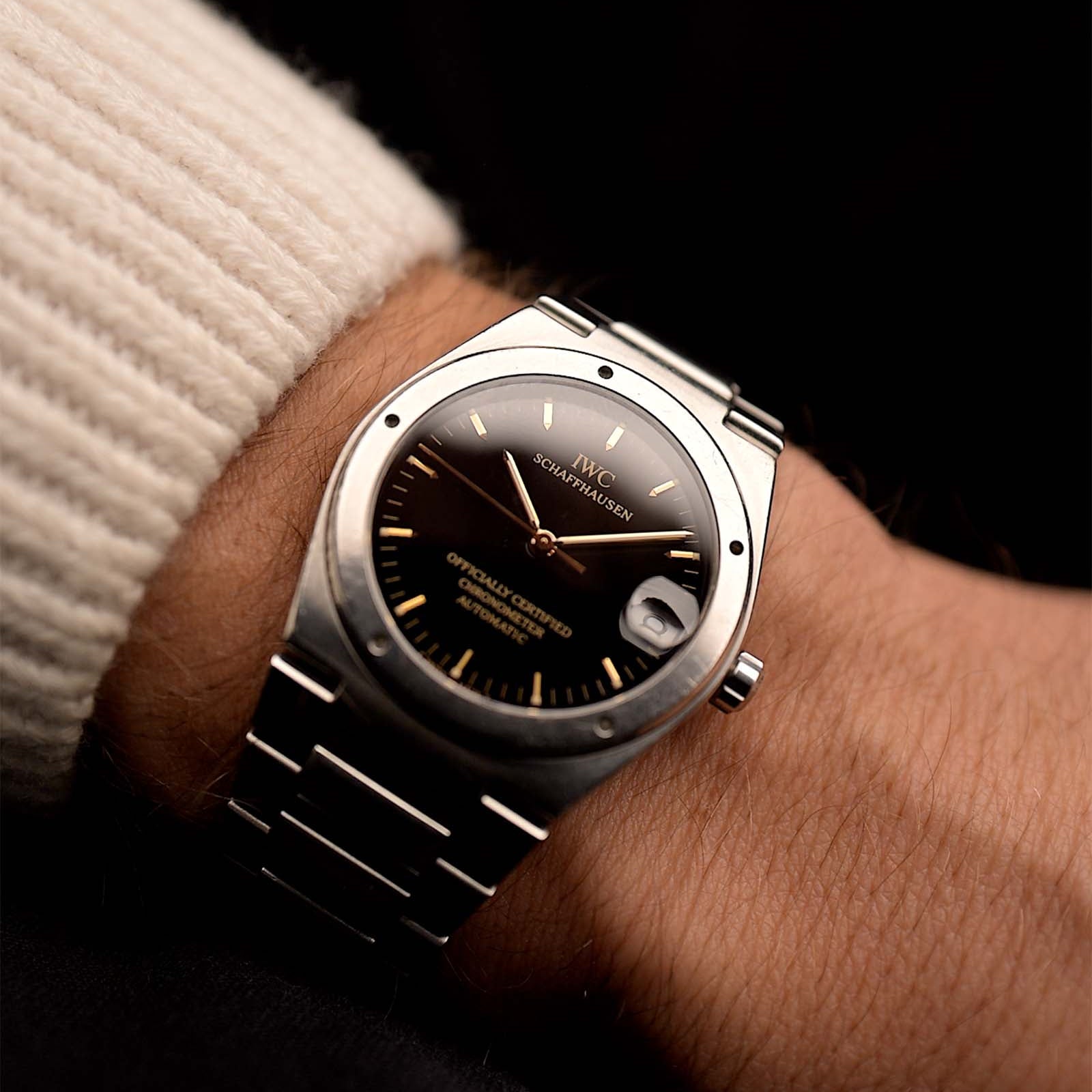 Vintage IWC Ingenieur 3521 watch from the 1990s on a wrist on black background. 34mm wide, Stainless Steel, Automatic movement (IWC Cal. 887/2), Flawless black dial and Stainless steel bracelet.
