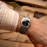 Vintage IWC Ingenieur 3521 watch from the 1990s on a wrist on beige background. 34mm wide, Stainless Steel, Automatic movement (IWC Cal. 887/2), Flawless black dial and Stainless steel bracelet.