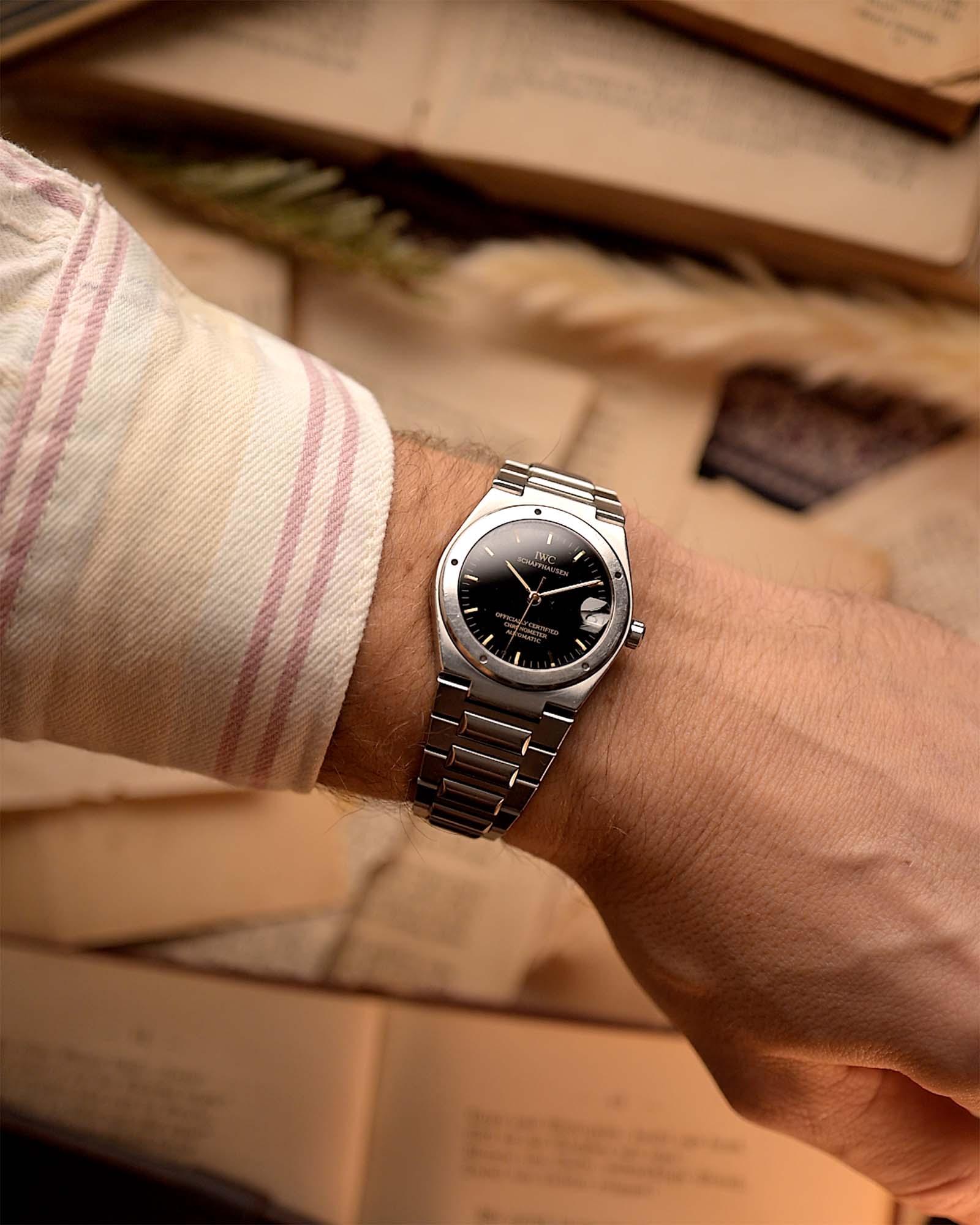 Vintage IWC Ingenieur 3521 watch from the 1990s on a wrist on beige background. 34mm wide, Stainless Steel, Automatic movement (IWC Cal. 887/2), Flawless black dial and Stainless steel bracelet.