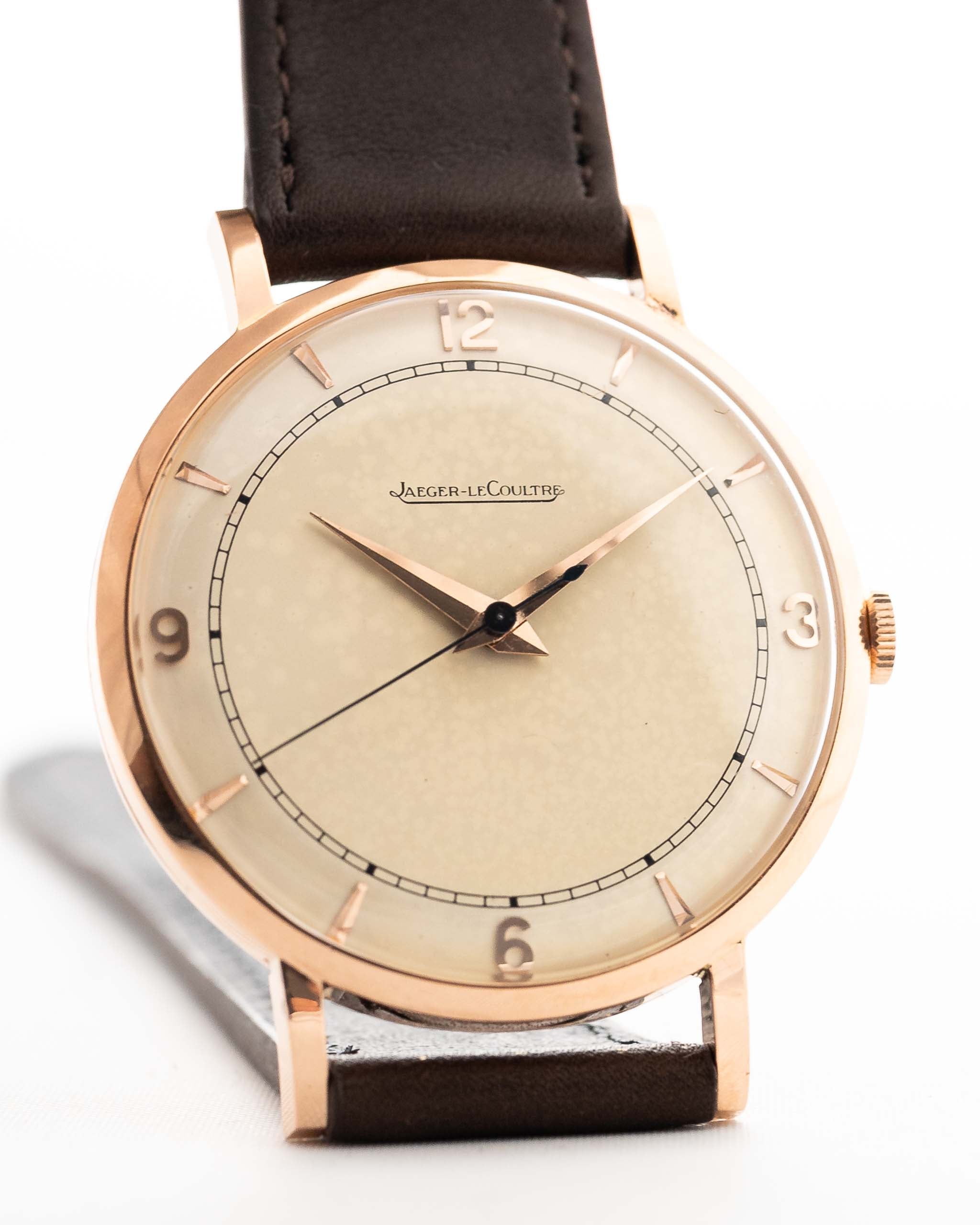 Rosegold Vintage Jaeger LeCoultre 18k Rose Railroad watch from the 1950s on a white background. 35mm wide with 18k Rose Gold Case, Manual Wind Caliber P450/4C, Cream Dial and Brown Leather Strap.