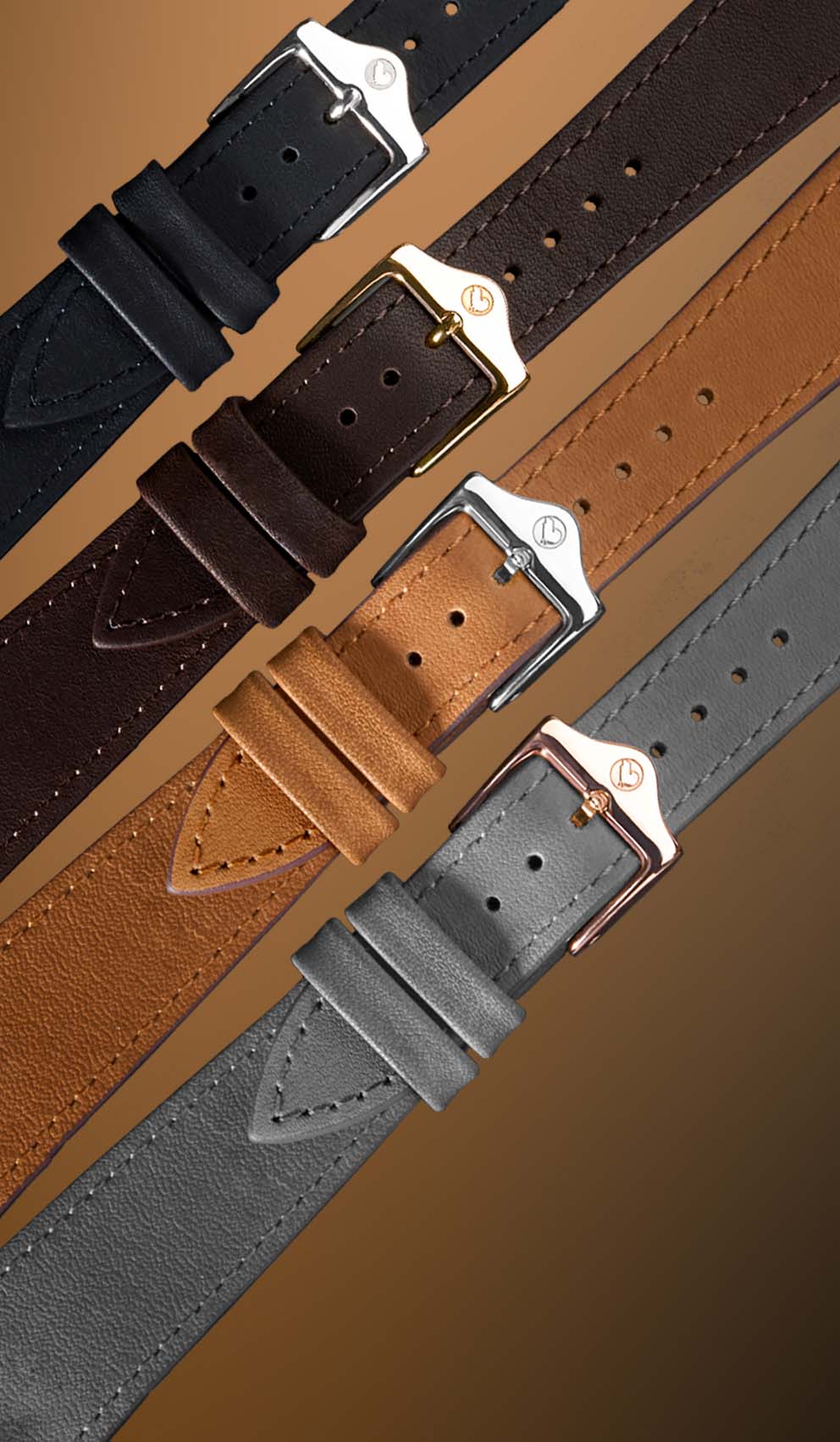 Four leather watch straps in black, brown, and gray with silver buckles on a brown background.
