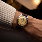 Omega Constellation 2852, steel with pie-pan dial, worn on the wrist over a warm backdrop
